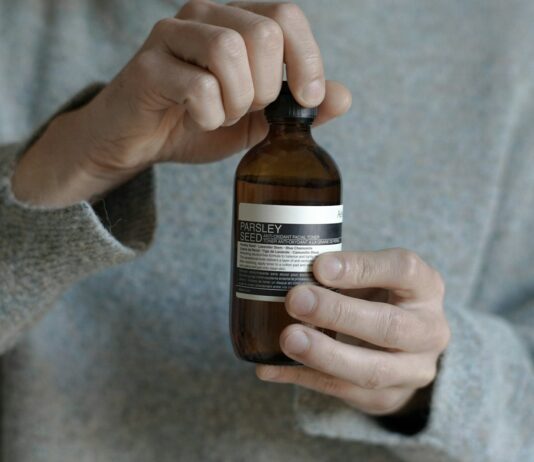 여름철 피지 조절 스킨케어 a person holding a bottle of beer in their hand