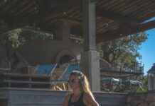 여름철 운동 후 스트레칭 루틴 woman in black sports bra and black shorts sitting on concrete bench during daytime