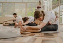 필라테스와 요가로 겨울철 에너지 충전하기 a group of people doing yoga in a room