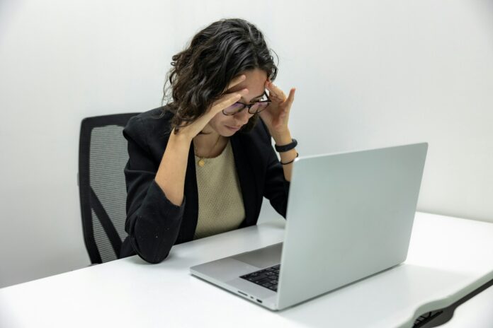 Photo by Resume Genius a woman sitting in front of a laptop computer