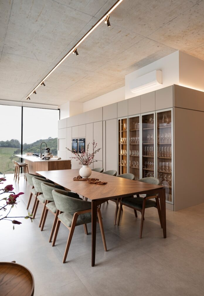 Modern dining room with large table and wine cabinet.