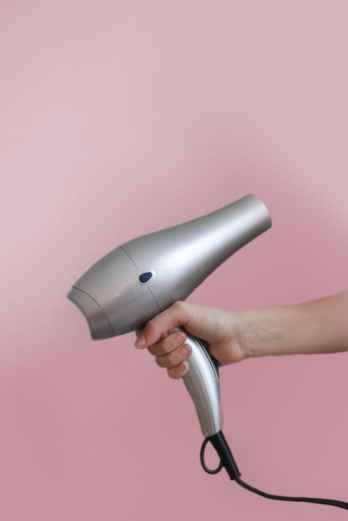 Photo by Element5 Digital person holding gray corded hair dryer