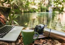 스마트폰 과몰입 시대, 일상에서 실천하는 ‘디지털 디톡스’ 건강 루틴 Laptop, camera, and mug by a forest stream