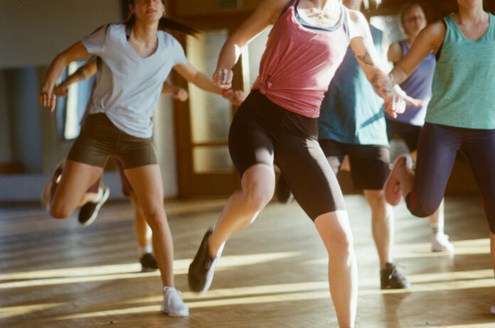 Photo by Kaspars Eglitis group of women running on brown wooden floor
